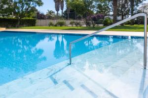 a swimming pool with blue water and metal railings at Apartment Santorini by Algarve Vacation in Alvor