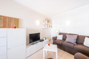 a living room with a couch and a tv at Apartment Santorini by Algarve Vacation in Alvor