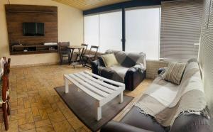 a living room with a couch and a table at Casa em Bombinhas Praia do Mariscal in Bombinhas