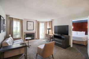 a hotel room with a bed and a living room at Sonesta ES Suites Huntington Beach Fountain Valley in Huntington Beach