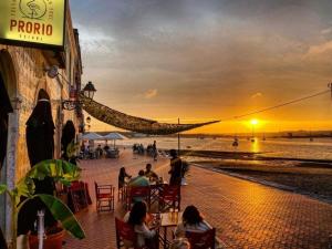 um grupo de pessoas sentadas em mesas na praia ao pôr do sol em Lisbon, 3 bedroom apartment in Amora , 15 min from the beach em Amora