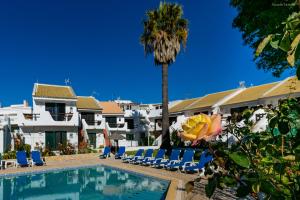 una piscina con sillas y una palmera en Torraltinha Sunset Apartment, en Lagos