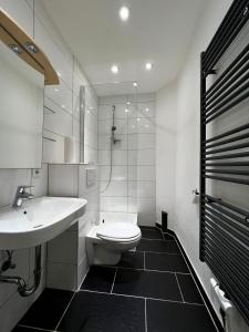 een witte badkamer met een wastafel en een toilet bij Ganze Wohnung Wiesbaden Stadtmitte 2 Zimmer Küche Bad mieten in Wiesbaden
