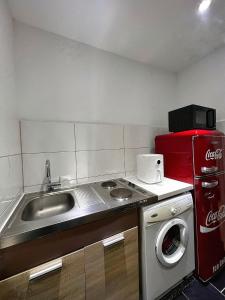 a kitchen with a sink and a coke machine at Ganze Wohnung Wiesbaden Stadtmitte 2 Zimmer Küche Bad mieten in Wiesbaden