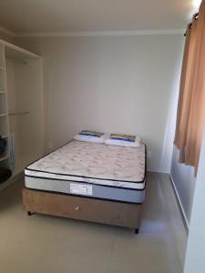 1 dormitorio pequeño con 1 cama en una habitación en Agradável apartamento em bairro silencioso..., en Camboriú