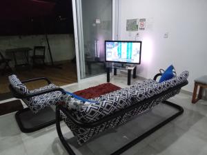 uma cadeira em frente a uma televisão numa sala de estar em Hospedagem Sol Nascente em Atibaia