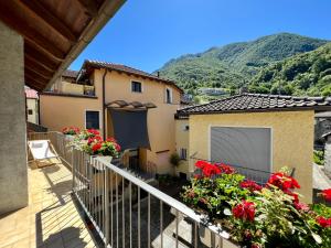 a balcony of a house with flowers and mountains at Boho Lake House - Private Beach 600m from the property - Free Parking - Home Cinema Room in Vira