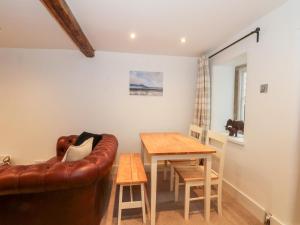 a living room with a couch and a table at Dragon Cottage in Bakewell