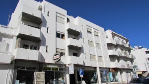 een groot wit gebouw met ramen aan een straat bij Apartamentos Julieta in Albufeira