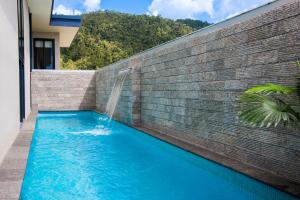 uma piscina com cascata numa parede de tijolos em 180 Degrees em Cannonvale
