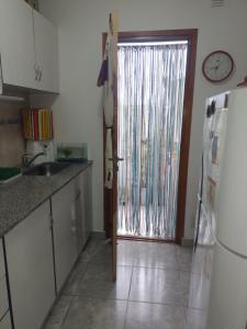 cocina con nevera y puerta corredera de cristal en Departamento Uriburu en Tandil