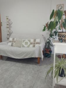 1 cama en una habitación blanca con plantas en Departamento Uriburu en Tandil