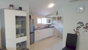 a kitchen with white cabinets and a sink at Apartments with parking space Milna, Brac - 11088 in Milna