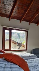 Un dormitorio con una gran ventana con un plano exterior en Kuntur Apart en El Chaltén