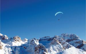 トレモージネ・スル・ガルダにあるCasa Nonno Bepiの雪山を飛ぶパラグライダー