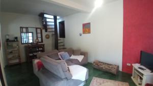 a living room with a couch and a television at Chale vista verde in São José dos Campos