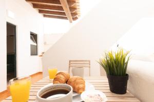 una mesa con un plato de cruasanes y zumo de naranja en GrowIN Digital Nomads, en Faro