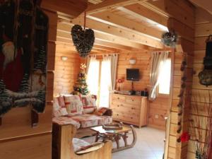a living room in a log cabin with a couch at Chalet haut de gamme avec sauna, terrasse et jardin près de la montagne vosgienne - FR-1-589-185 in Saint-Nabord
