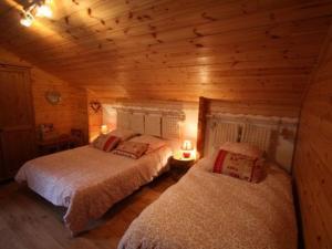 een slaapkamer met 2 bedden in een blokhut bij Gîte Saint-Nabord, 4 pièces, 6 personnes - FR-1-589-185 in Saint-Nabord