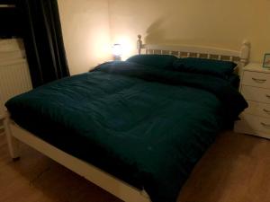 łóżko z zieloną kołdrą w sypialni w obiekcie Private room in Highgate London w Londynie