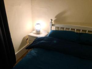 a bedroom with a bed with a lamp on a night stand at Private room in Highgate London in London
