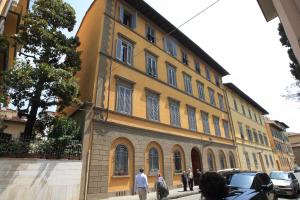 un gran edificio amarillo con gente caminando delante de él en MDR NumberSix Suites, en Florencia