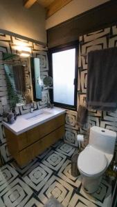 a bathroom with a toilet and a sink and a window at Casa William en el bosque in Valle de Bravo