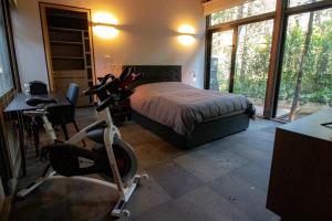 Dormitorio con cama y bicicleta estática en Casa William en el bosque en Valle de Bravo