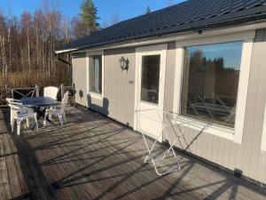 un porche cubierto con mesa y sillas en la cubierta en Holiday home NORDMALING en Nordmaling