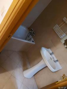 y baño con aseo blanco y lavamanos. en Hostal “ INFANTAS”, en Madrid