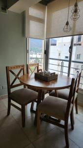 una mesa de comedor y sillas con una gran ventana en Departamento - Excelente ubicación, Zona Centro. en Salta