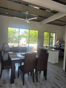 - une salle à manger avec une table, des chaises et des fenêtres dans l'établissement Casa Vacacional en Carmen de Apicala, Colombia, à Carmen de Apicalá