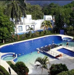 - une grande piscine bleue avec des personnes dans l'établissement Casa Vacacional en Carmen de Apicala, Colombia, à Carmen de Apicalá