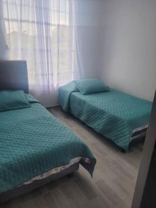 1 dormitorio con 2 camas y ventana en Casa Vacacional en Carmen de Apicala, Colombia, en Carmen de Apicalá