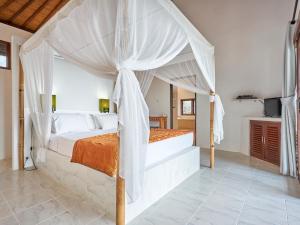 a bedroom with a bed with a canopy at Anda Amed Villas & Spa in Amed