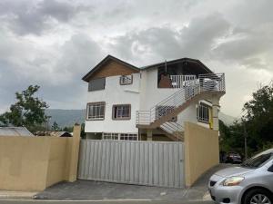 a white house with a staircase on top of it at Oasis de Paz 1.2 in Jarabacoa