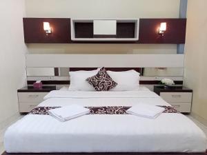 a bedroom with a large white bed with two pillows at Hotel Pilar Mosa in Muarawahau