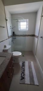 La salle de bains est pourvue de toilettes, d'une douche et d'un tapis. dans l'établissement Jamaica Tranquility, à Lucea
