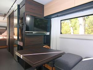 a small living room with a table and a tv at Dreamer luxury caravan on the backwaters, Lütow in Lütow