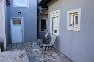 a patio with two chairs and a table next to a building at Apartmani 15 in Cetinje