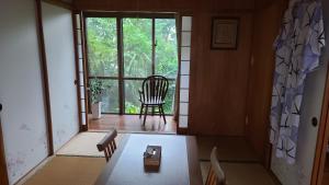 a room with a chair and a window at Haruka 和室 in Naha