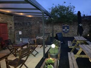 a patio with tables and chairs under a pergola at The Star Inn in Nafferton