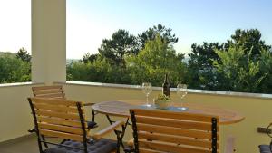 a table with two glasses of wine on a balcony at Apartment Karmen in Šilo