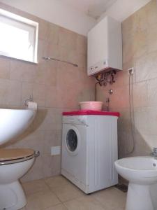een badkamer met een wasmachine en een toilet bij House Buneta in Ližnjan