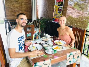 Un uomo e una donna seduti a un tavolo con del cibo di Rodrigo's Villa & Restaurant a Negombo