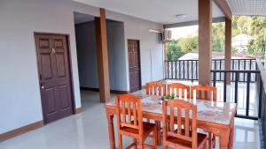 a dining room with a table and chairs on a balcony at WS HOUSE KRABI in Ban Ko Kwang
