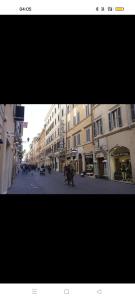 een straat met gebouwen en mensen die op straat lopen bij Contemporary art by Spanish step in Rome