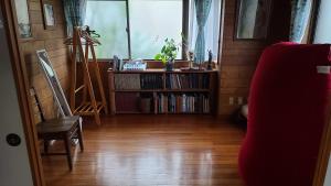 a living room with a book shelf and a window at Haruka 和室 in Naha