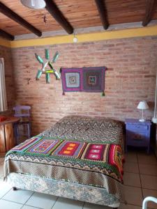 a bedroom with a bed and a brick wall at Madrenatura in Mina Clavero