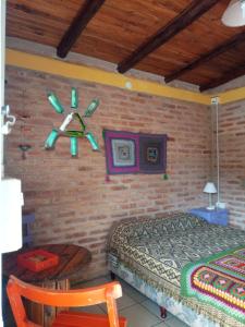 a bedroom with a bed and a brick wall at Madrenatura in Mina Clavero